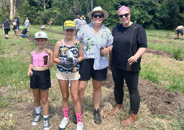 Adults and kids volunteering at the tree planting working bee.